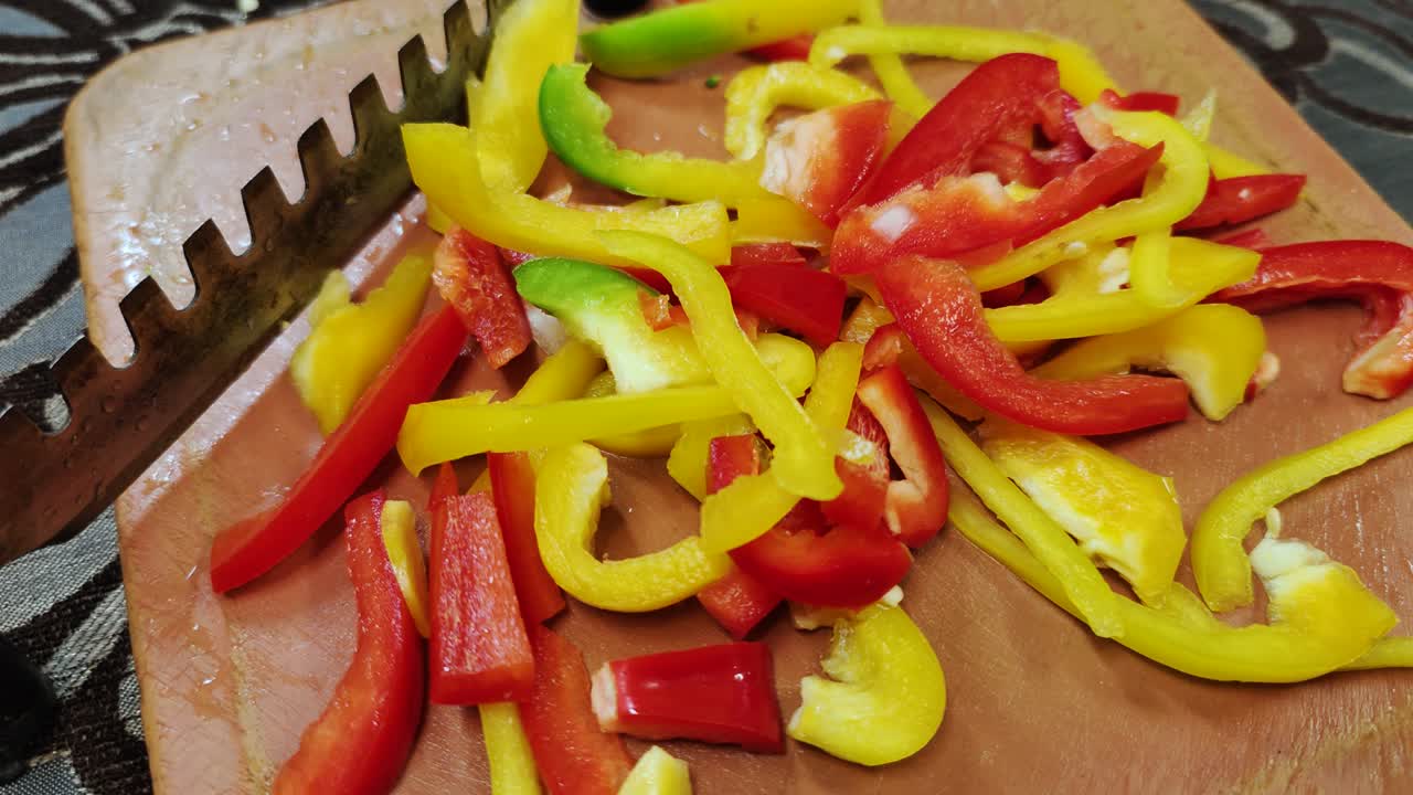 신선한 빨간색과 노란색 고추는 스테인리스 스 칼날로 갈색 채소 절단기에 어