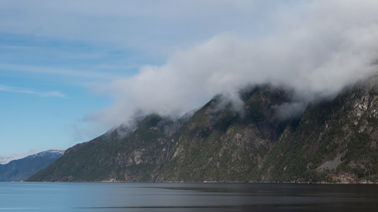 Time lapse panoramico di nuvole che si muovono lentamente sulle montagne accanto ai fiordi in Norvegia in una giornata di sole splendente