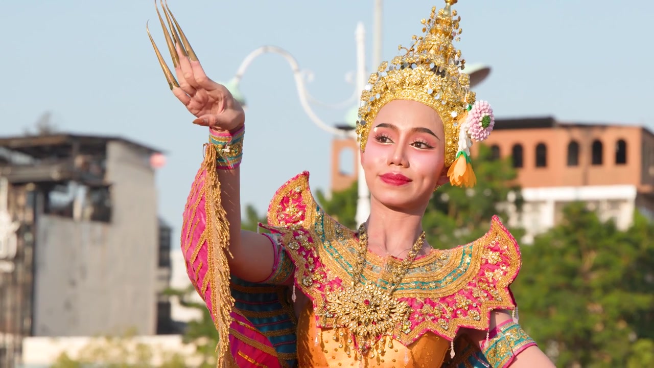 En thailandsk kvinde udfører traditionel Manohra-dans iført udsmykket guldkostume og lange negle