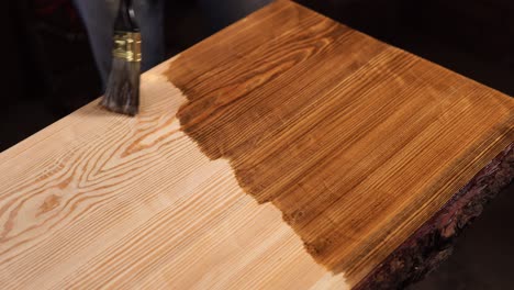 applying wood stain to a table top