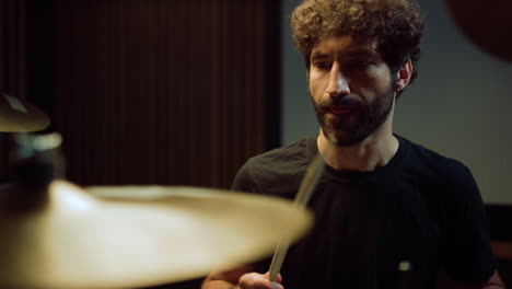 musician playing on drum kit in studio. artist jumping during repetition indoor.