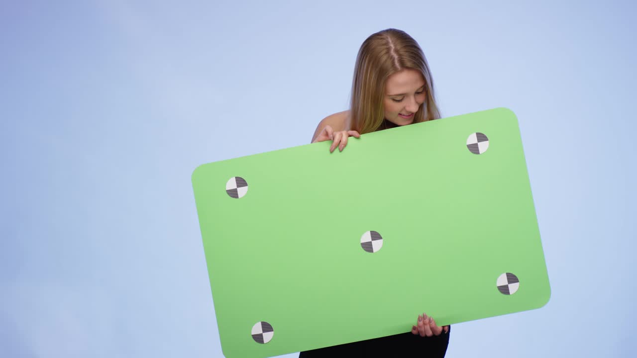 feliz mujer sonriente sosteniendo una tarjeta en blanco de gran tamaño y mirando a la cámara