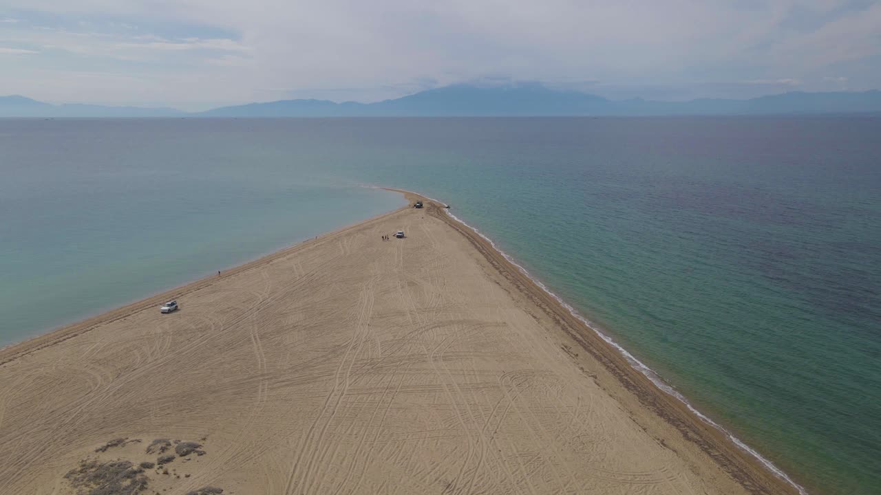 에파노미, 할키디키, 그리스의 열대 해변에 있는 반도 위로 4k 옆으로 움직이는 클립