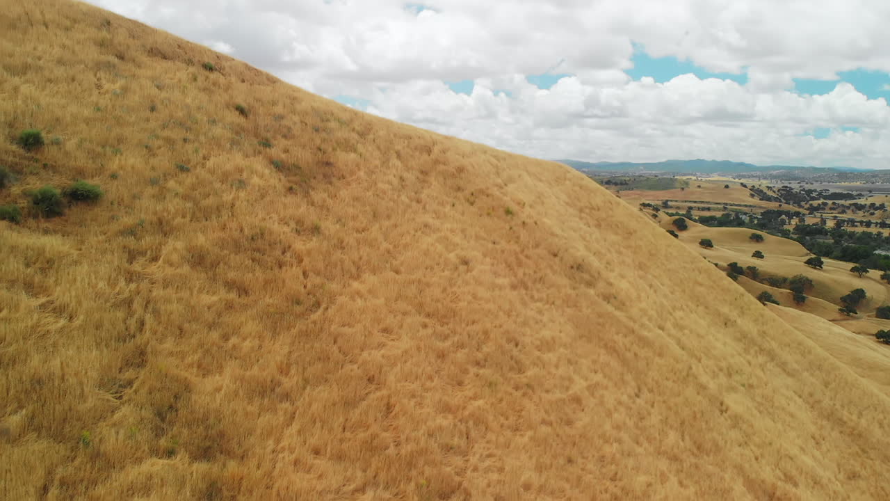 revelación del paisaje de la colina de hierba seca desde detrás de la colina, antena