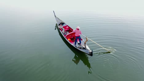 beautiful woman sailing in gondola. gondolier with oar moving boat slowly. gondola floating the calm river in the evening.