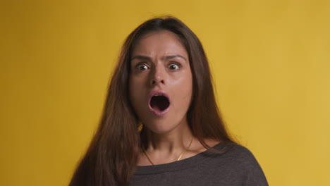 studio portrait of excited woman celebrating good news winning money against yellow background 3