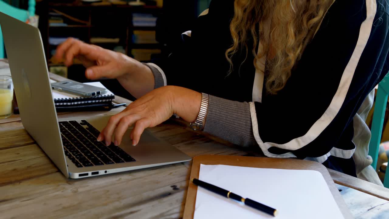 Donna matura che usa il laptop a casa 4k