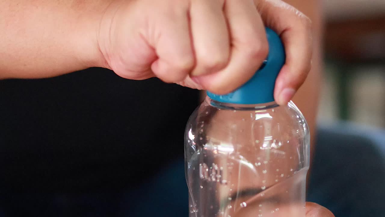 시장에서 병을 열고 있는 손