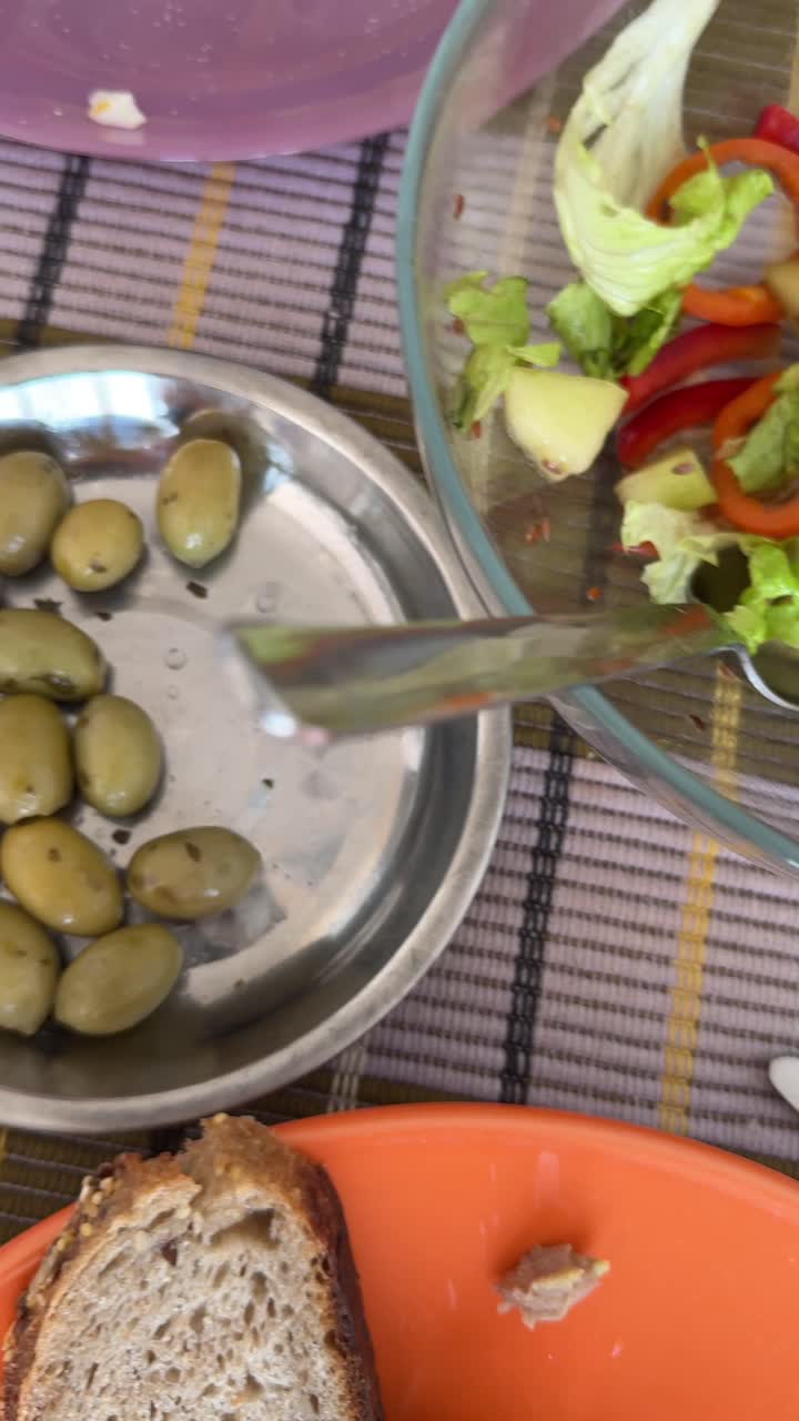 Picnic lunch with salad, olives, bread, and ham