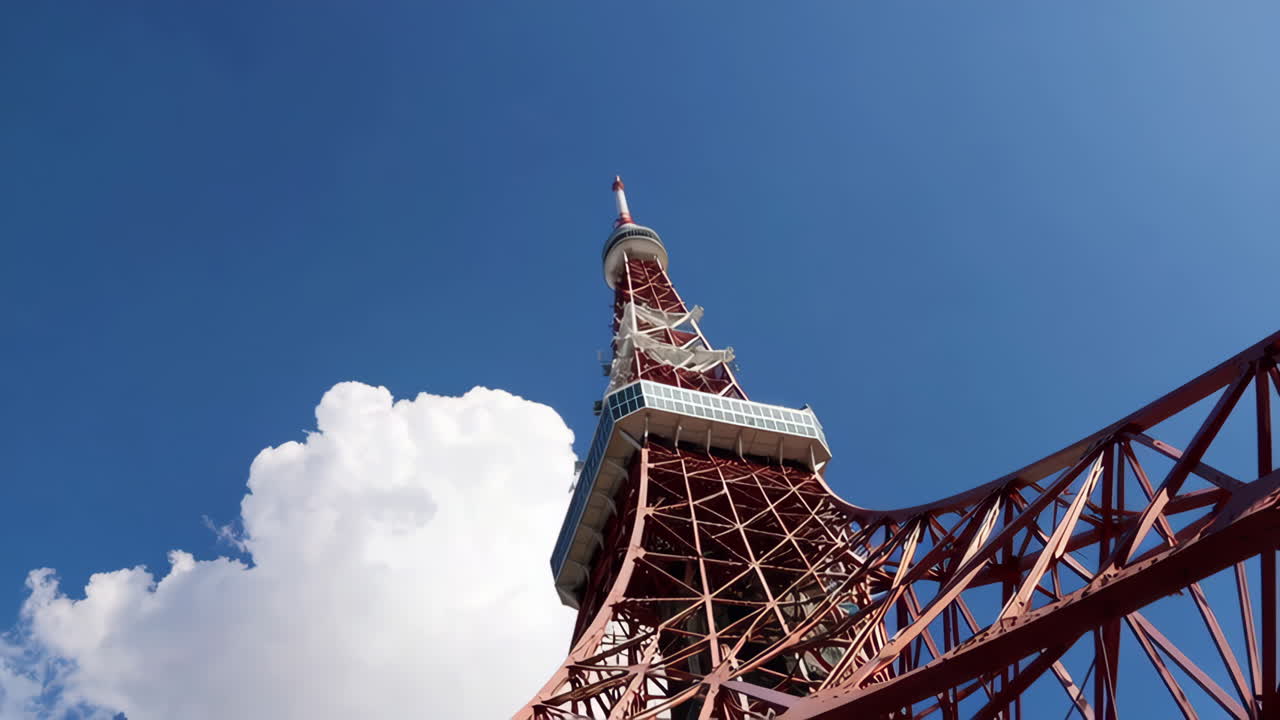 Tokyo Tower against a clear blue sky with white clouds
