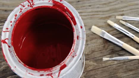 close up of red paint can and brushes