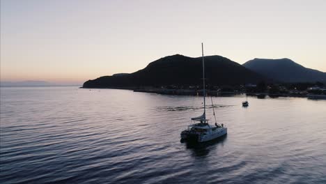 sailboat off the coast at sunset aerial