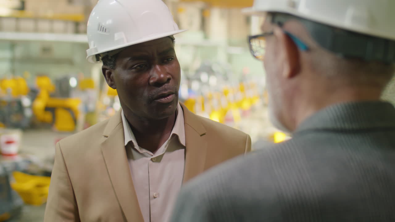 African American Factory Engineer Having Talk with Colleague