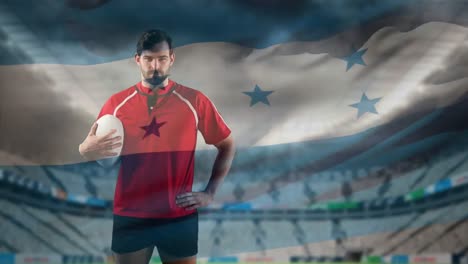 jugador de rugby profesional de pie frente a una bandera y un estadio