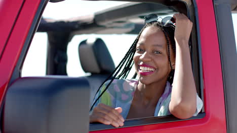 african american woman smiles from a car window on a road trip with copy space