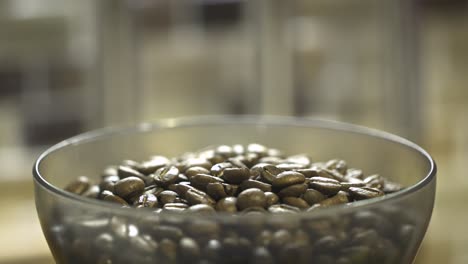 basket of roasted beans shaking and moving down with the coffee grinder in the kithen at nighttime