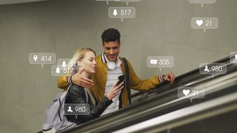 animation of social media icons floating over happy diverse couple embracing on moving stairs