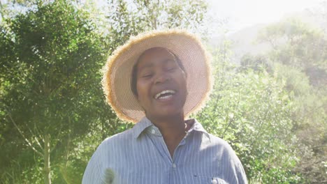 feliz mujer mayor afroamericana mirando a la cámara al aire libre