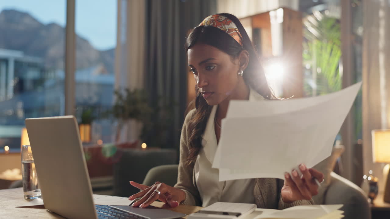 Donna che lavora al laptop con documenti nell'ufficio di casa
