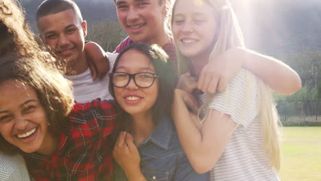 Amigos-De-La-Escuela-Adolescentes-Sonriendo-A-La-Cámara-Al-Aire-Libre,-De-Cerca