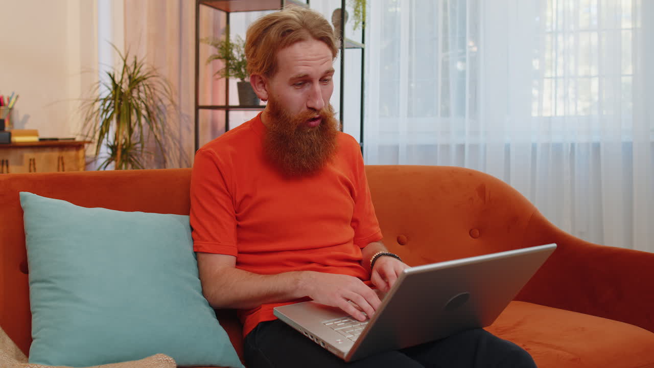 удивленный молодой человек использует ноутбук, получает хорошие новости, шокирован победой, празднует победу