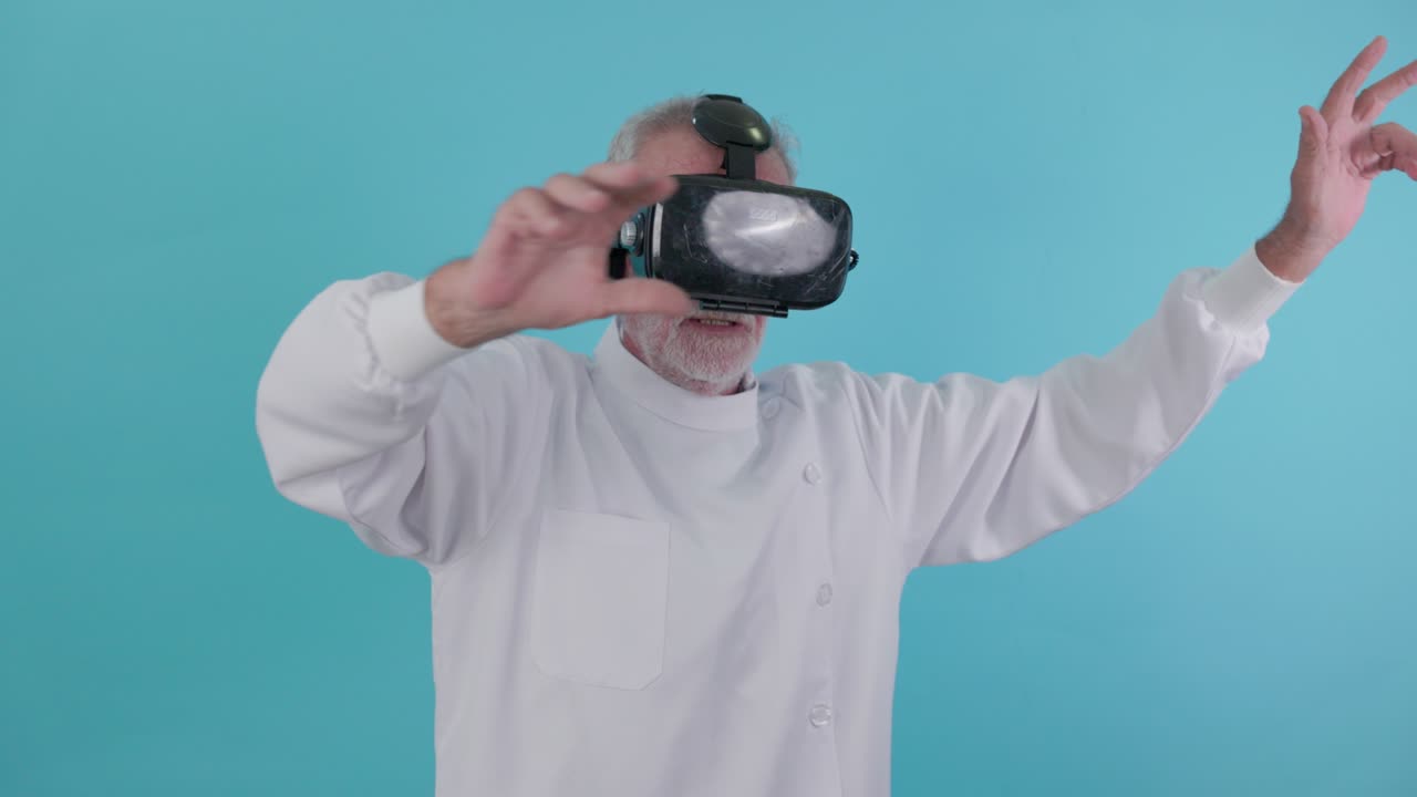 con un fondo azul, un médico barbudo senior juega con gafas de realidad virtual.