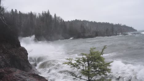 ásperas olas de tormenta chocando contra acantilados rocosos en un día sombrío, cámara lenta