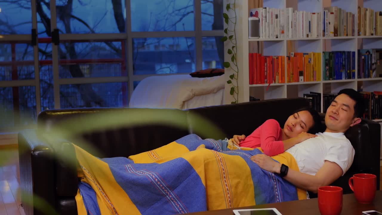 커플이 거실의 소파에서 휴식을 취하고 있다