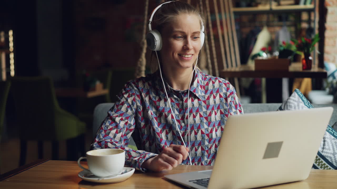 Kvinde, der arbejder på bærbar computer på en café