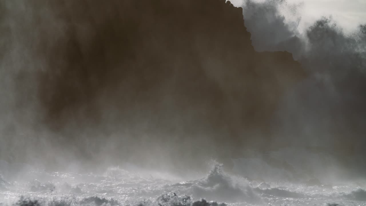 거대한 파도가 슬로우 모션으로 바위가 많은 해안으로 굴러간다 1