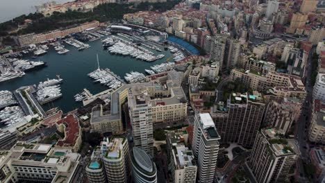 Monaco-City-Boats-and-Yachts-in-Port-Harbor-Marina,-Aerial-Drone-Tilt-up-Reveal