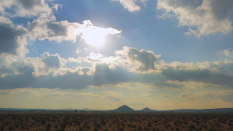 In-hopes-of-needed-rain,-storm-clouds-form-above-the-arid-Mojave-Desert-basin---pull-back-aerial-view