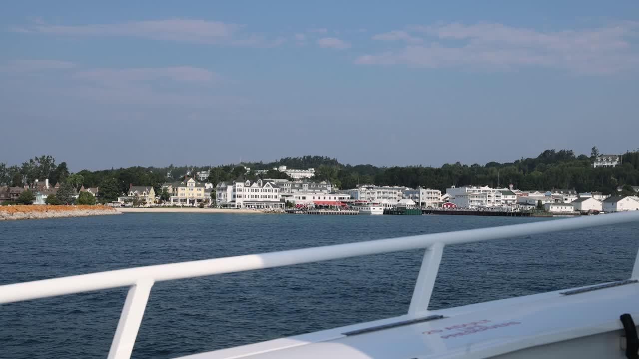 View of the Grand Hotel on Mackinac Island and the marina in the distance while riding on a ferry