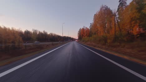 pov: driving on highway entrance ramp through colorful autumn trees