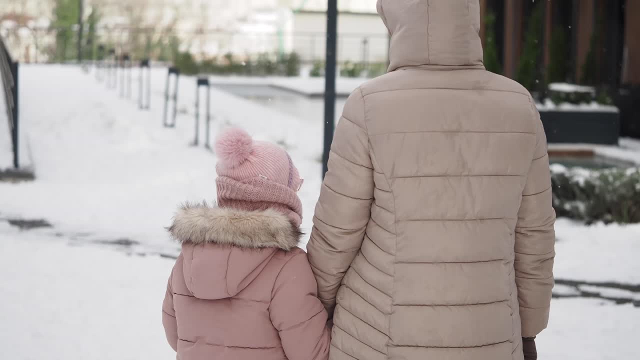 Mother and Daughter Walking in Winter Snow