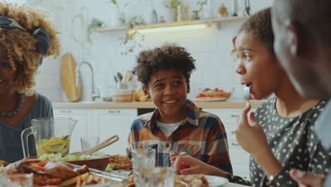hermano pequeño y hermana disfrutando de la cena de vacaciones con la familia en casa