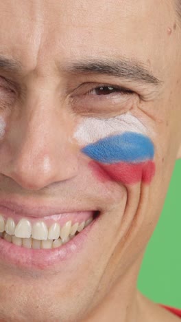 man with a russian flag painted on the face smiling