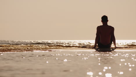 Silueta-De-Un-Joven-Sentado-En-Una-Pequeña-Isla-De-Arena