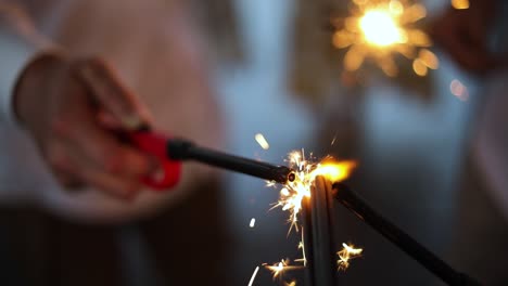 slow motion shot of a group of people using a lighter to light their sparklers fireworks for an event of celebration