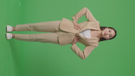 cuerpo lleno de mujer de negocios asiática sonriendo cálidamente en el fondo de la pantalla verde en el estudio