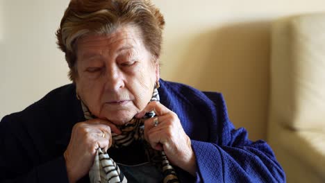 modern grandmother putting on fancy blue jacket getting ready to go out