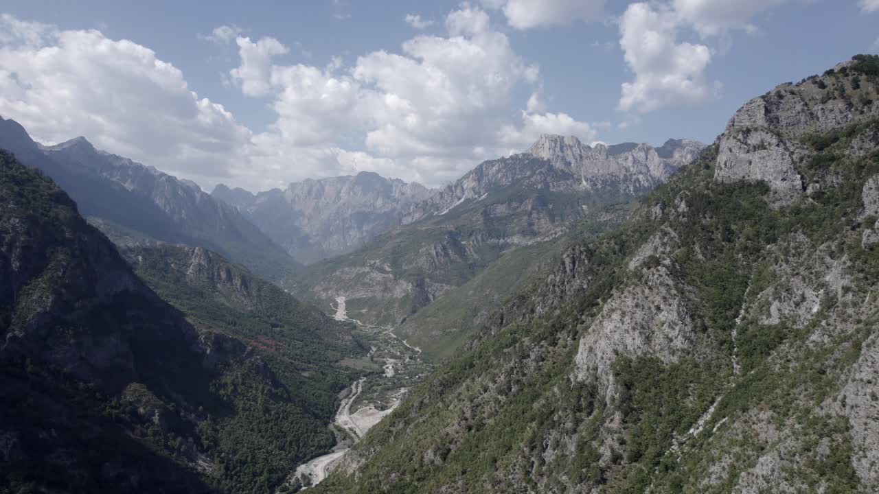 video frontal de drones que avanza sobre el valle de valbone, albania, condado de rogam, se pueden ver casas pequeñas y el río con poca agua