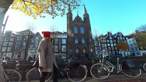 Beautiful-girl-walking-by-Dutch-canal-and-houses-in-Holland-on-a-sunny-day