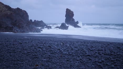 high waves crashing on the black rocks in iceland and spraying around during a storm
