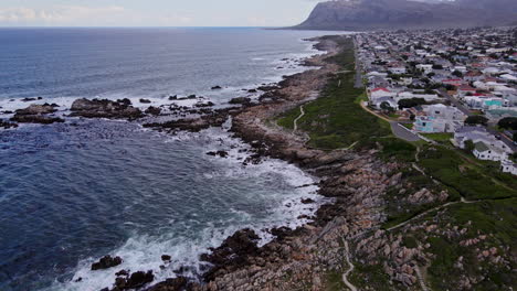 jagged coastline of coastal town kleinmond on overstrand, aerial tilt-up