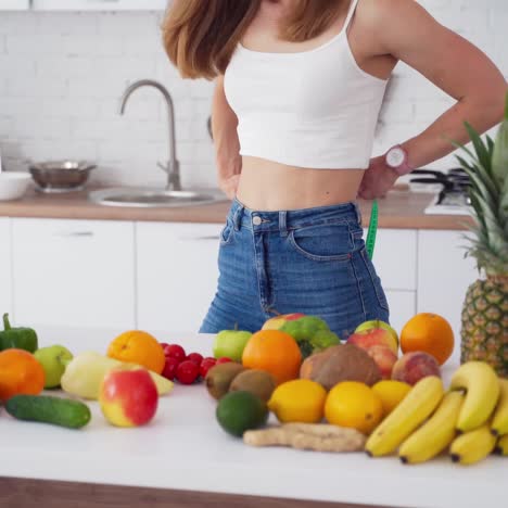 Sporty young woman in light kitchen