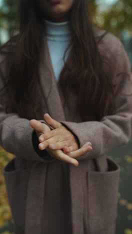 mujer con un abrigo beige en un parque de otoño