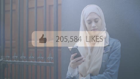 speech bubble with thumbs up icon and increasing numbers against woman in hijab using smartphone