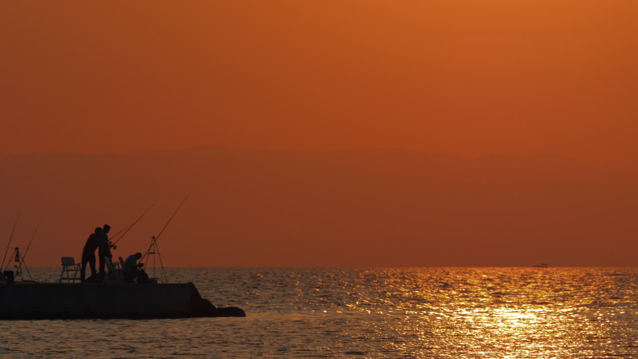 Scena serale del mare e pescatori sul molo