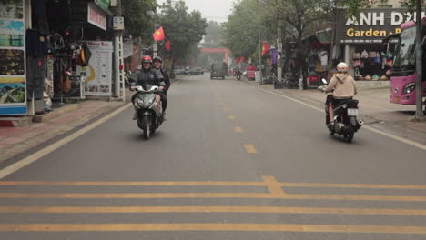 couple riding motorbike through vietnamese city street